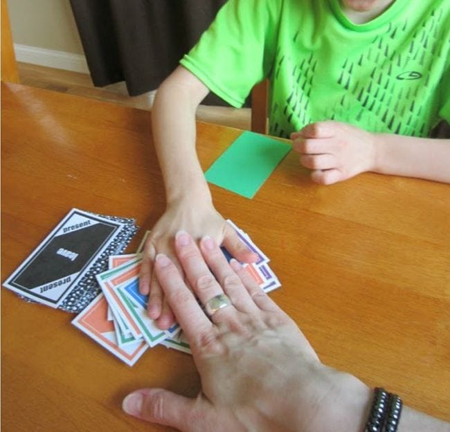 child and adult hand slapping a pile of cards 