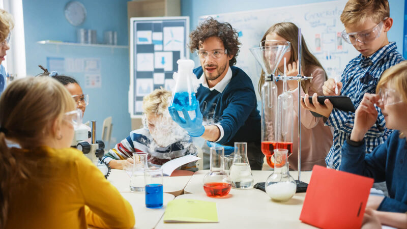 Wards Science Hero School Science Classroom: Enthusiastic Teacher Explains Chemistry to Diverse Group of Students. Science Resources for Middle and High School